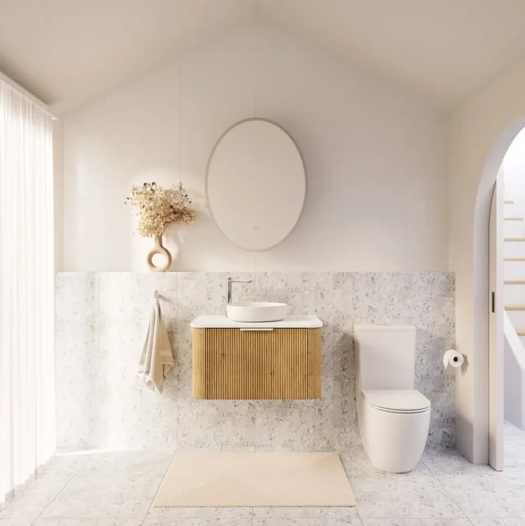 Modern minimalist bathroom with stone tile walls, timber vanity, and soft neutral styling.