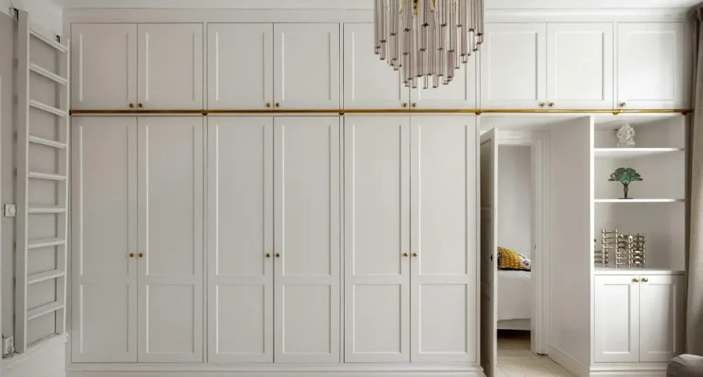 Wall-to-wall white cabinetry with integrated open shelving and brass hardware in a contemporary home.