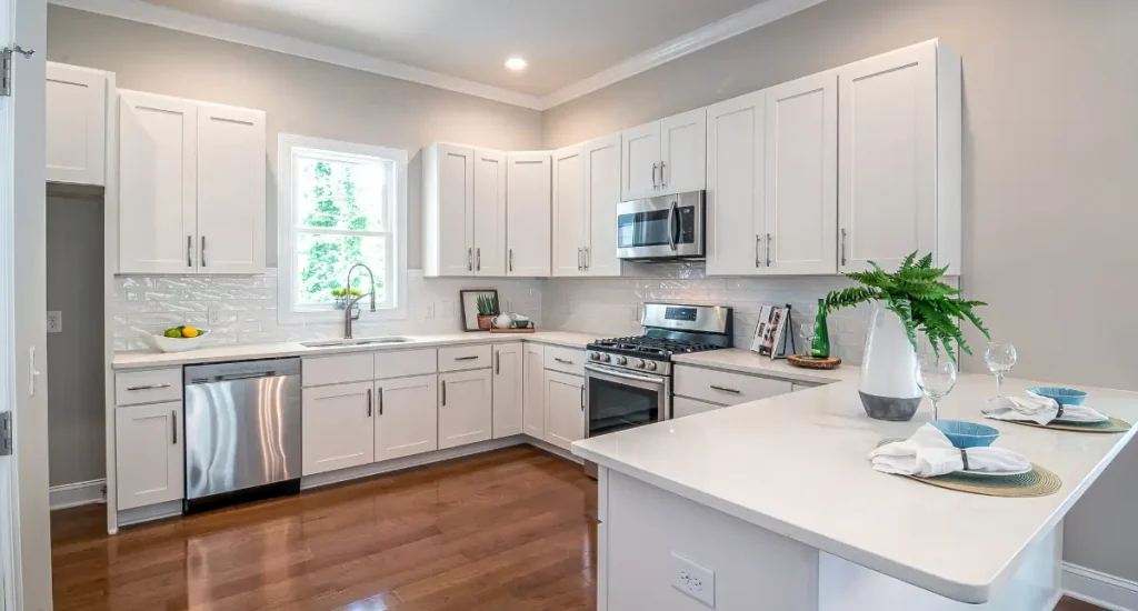 Bright modern kitchen with white shaker cabinets, stainless steel appliances, and a breakfast bar.