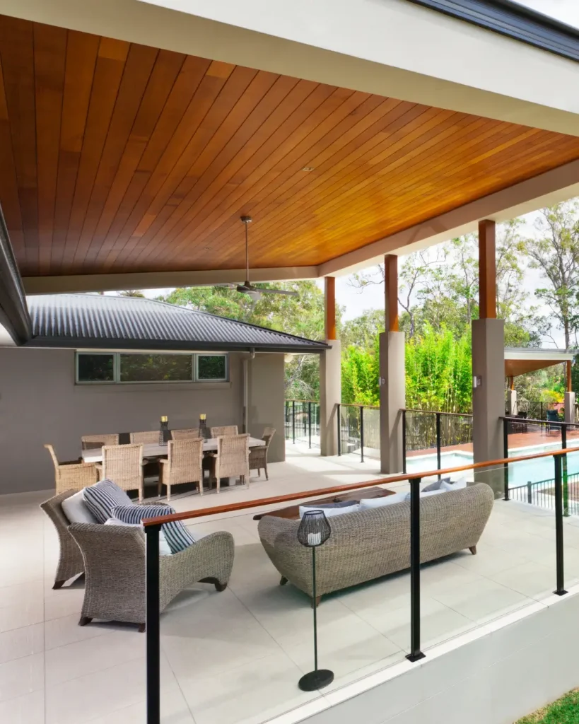 Spacious outdoor entertaining area with wicker lounge and dining set under a timber ceiling.