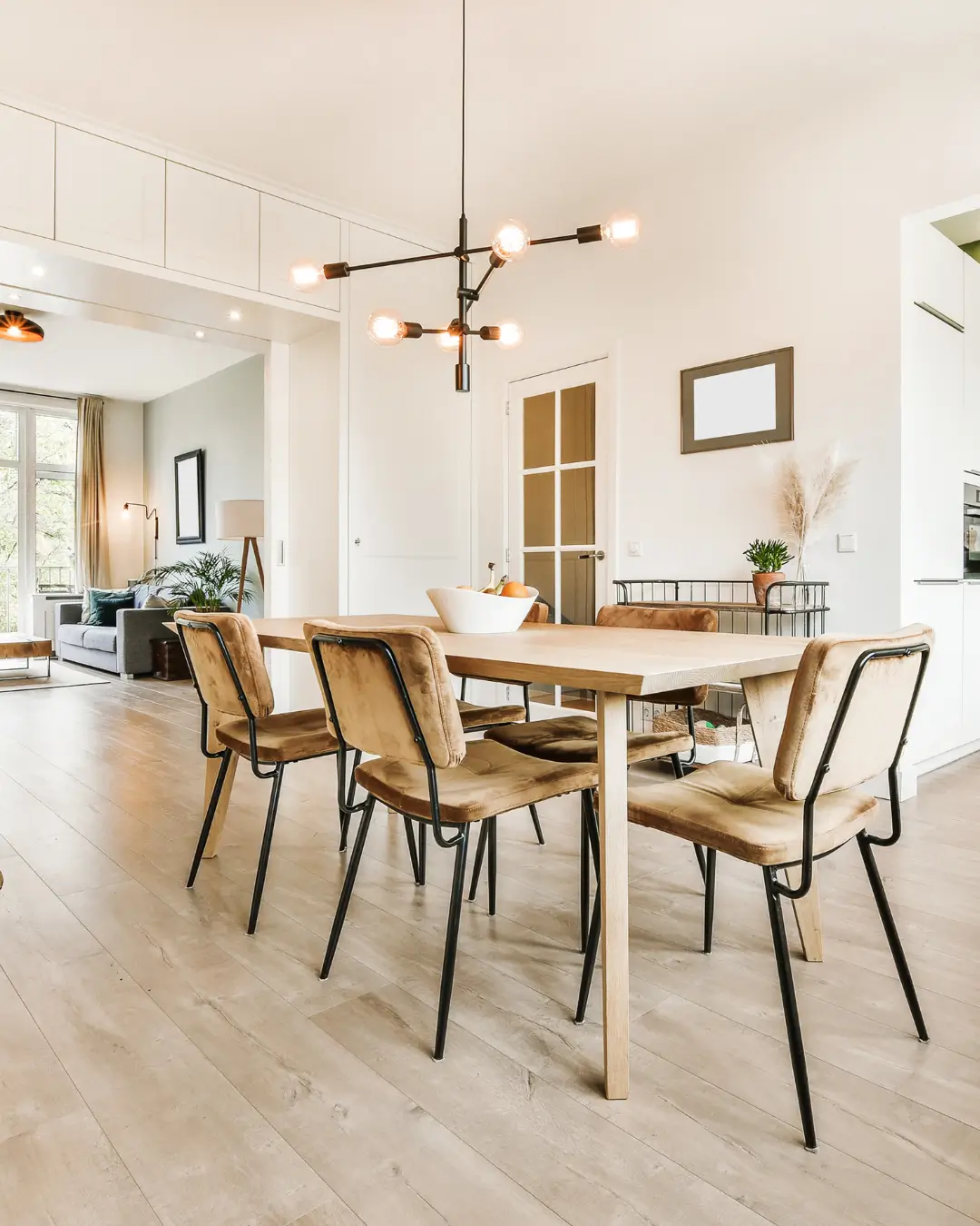 Stylish open-plan dining room with timber floors and industrial-style lighting.
