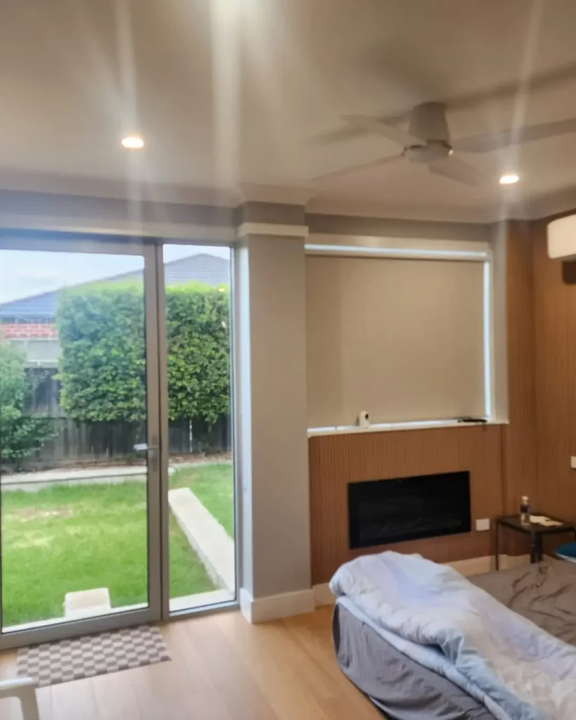 Bedroom with timber floors and sliding glass doors opening to a private backyard.