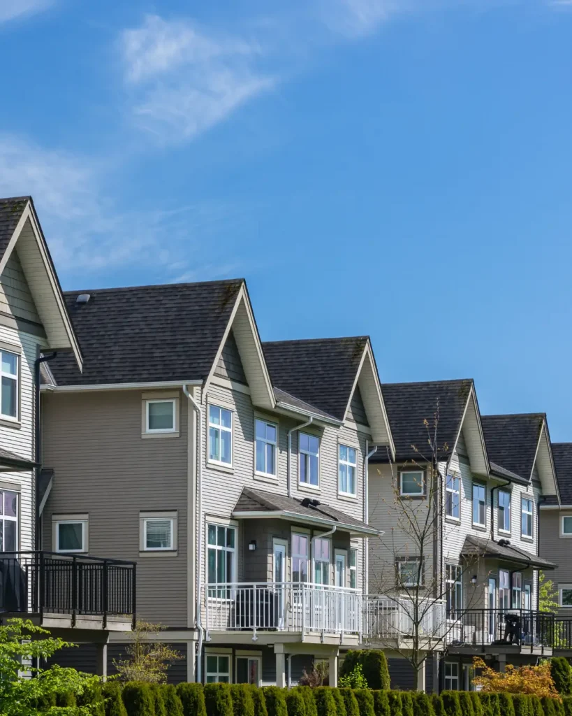 Modern double-storey townhouses with balconies and gable roofs in a residential development