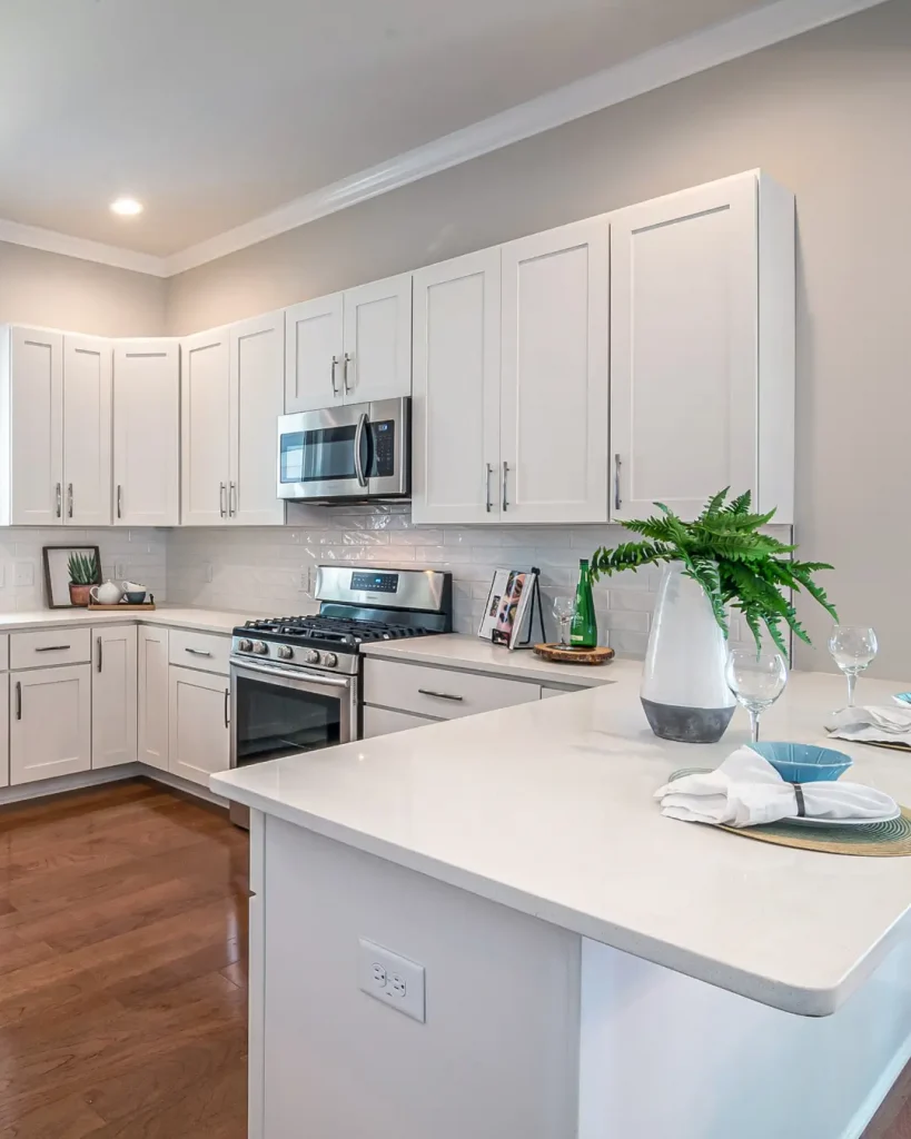 Modern kitchen with white shaker cabinets, stainless steel appliances, and breakfast bar.
