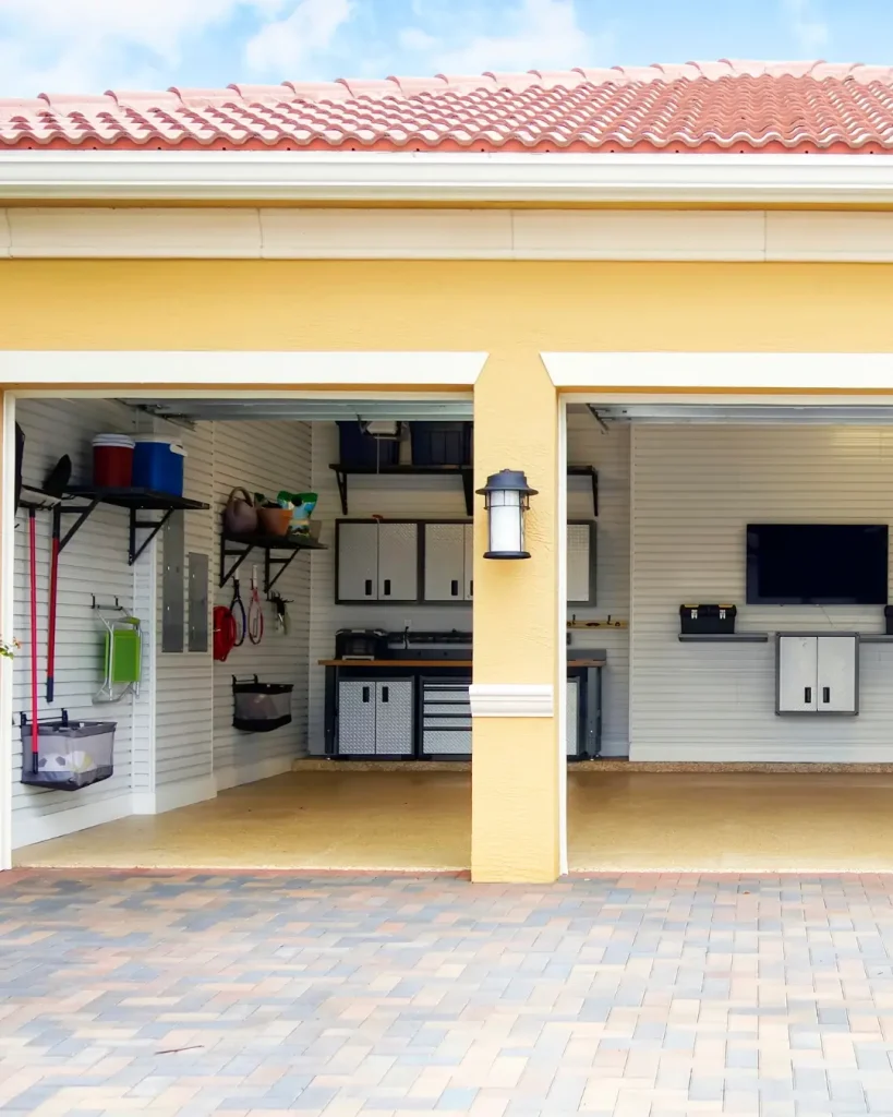 Organised garage with wall-mounted storage, cabinets, and tool bench.