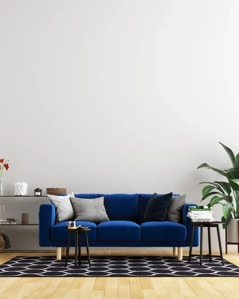 Modern garage conversion featuring a deep blue sofa, wooden flooring, and minimal decor.
