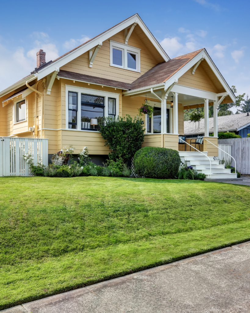 Melbourne weatherboard home with yellow facade, white trim, and manicured front lawn.