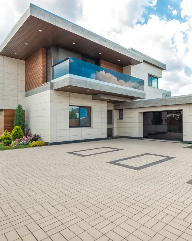 Modern double-storey home with sleek lines, glass balcony, and tiled driveway in Melbourne.