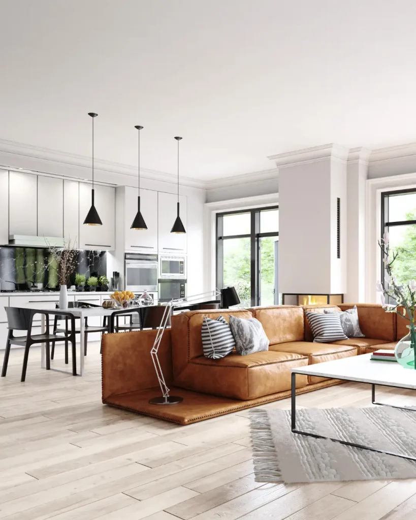 Contemporary open-plan kitchen and living area with leather sofa and pendant lighting.