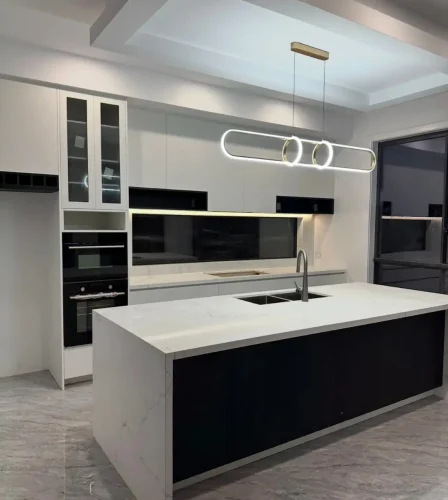 Contemporary kitchen with island bench, integrated appliances, pendant lighting, and marble finishes.