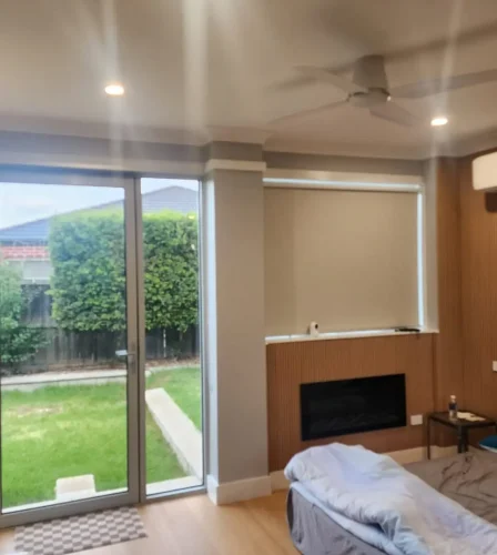 Bedroom with timber floors and sliding glass doors opening to a private backyard.