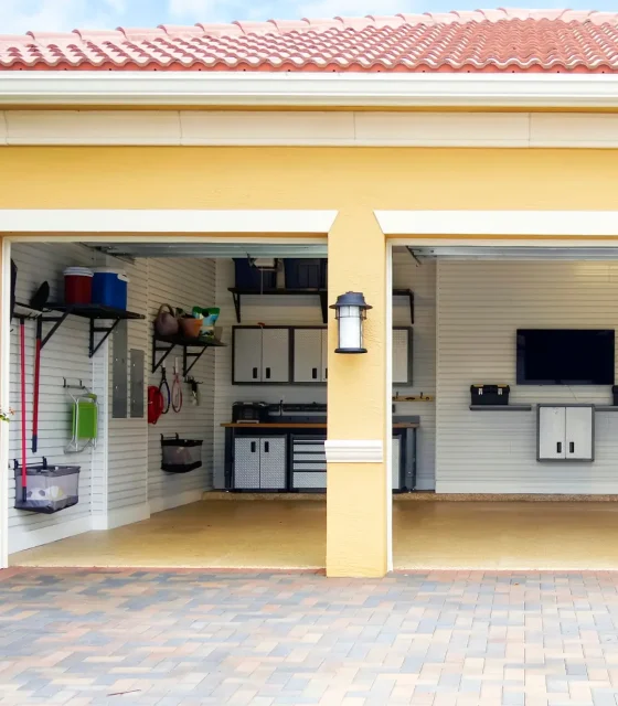 Organised garage with wall-mounted storage, cabinets, and tool bench.