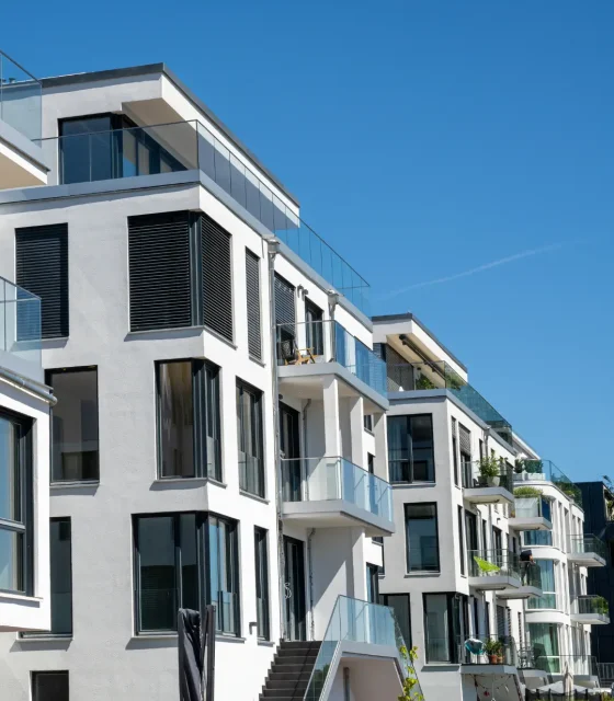 Contemporary apartment-style multi-unit dwellings with floor-to-ceiling glass and balconies